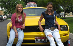 two girls on yellow car